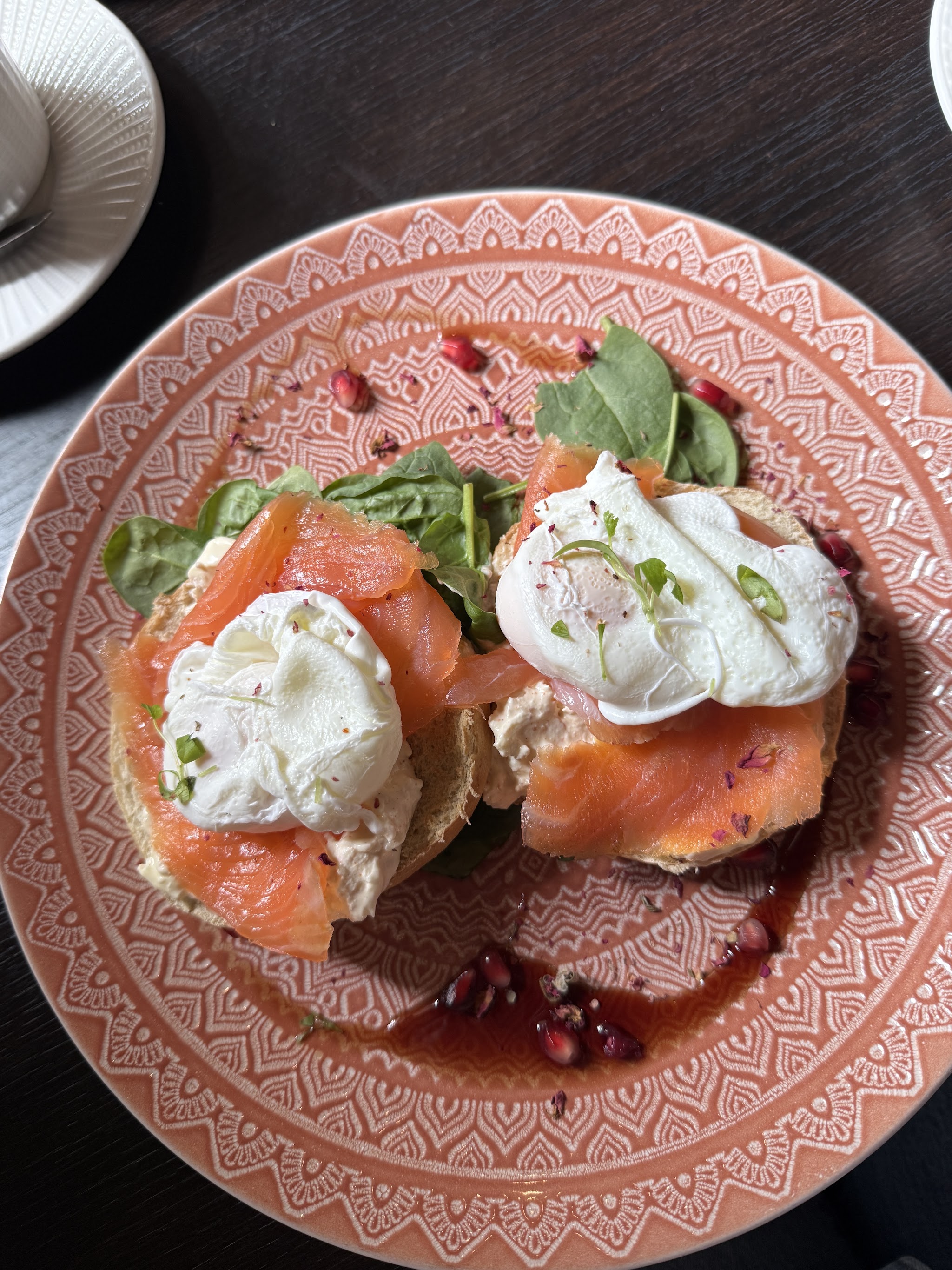 Poached eggs and salmon on a pink patterned plate