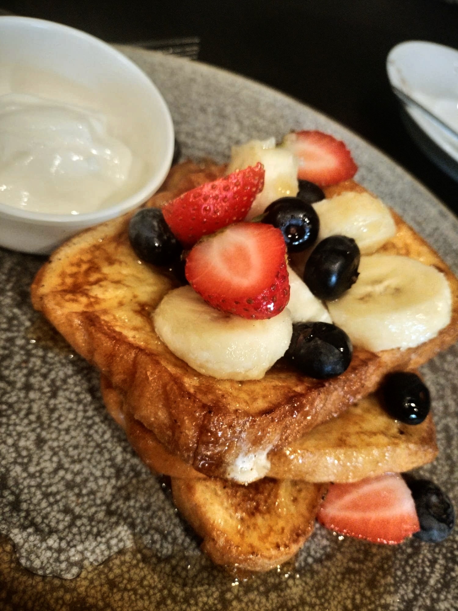 Golden French toast topped with strawberries, banana and blueberries