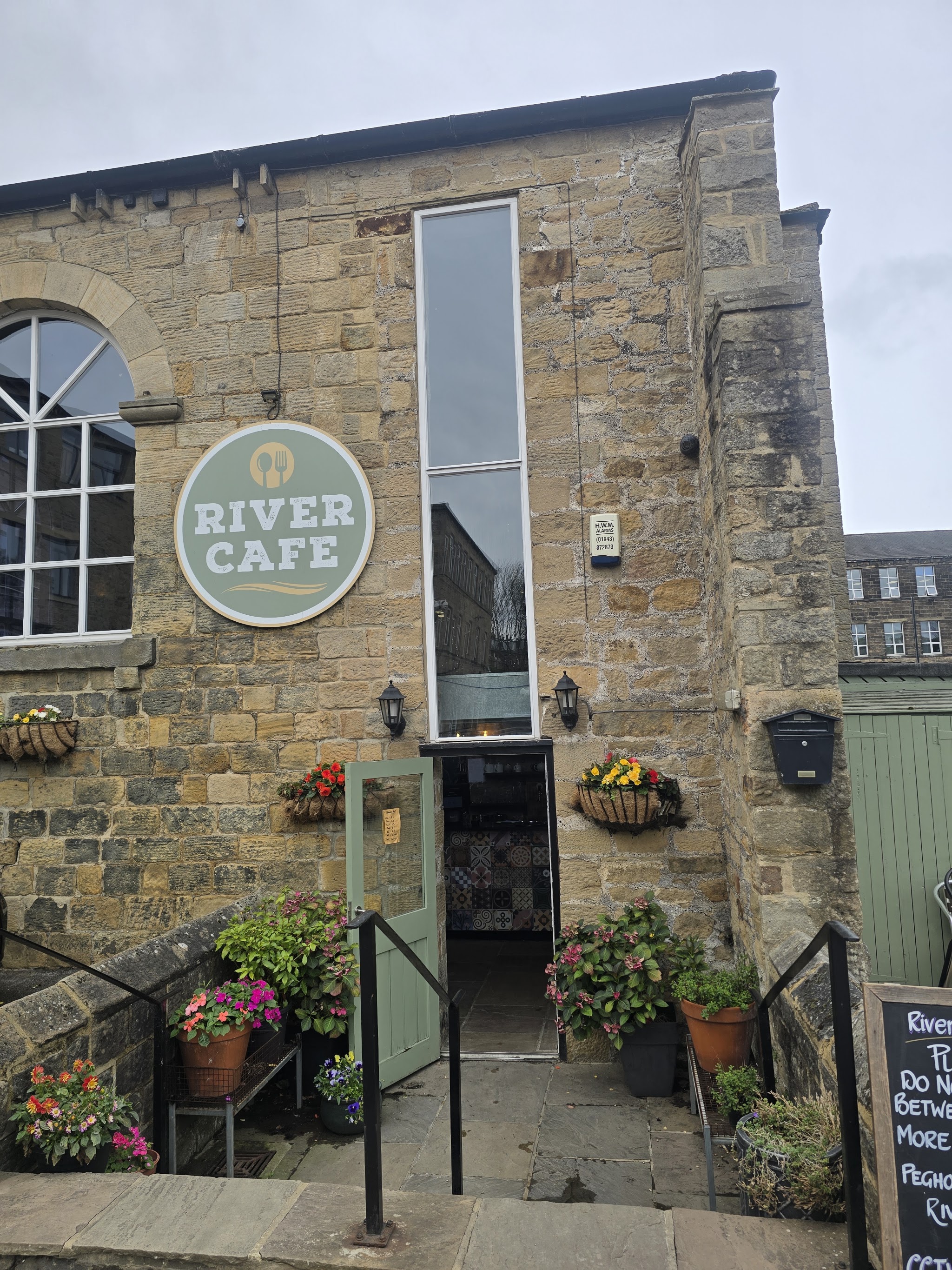 River Cafe's sage sign above the entrance to its stone mill building