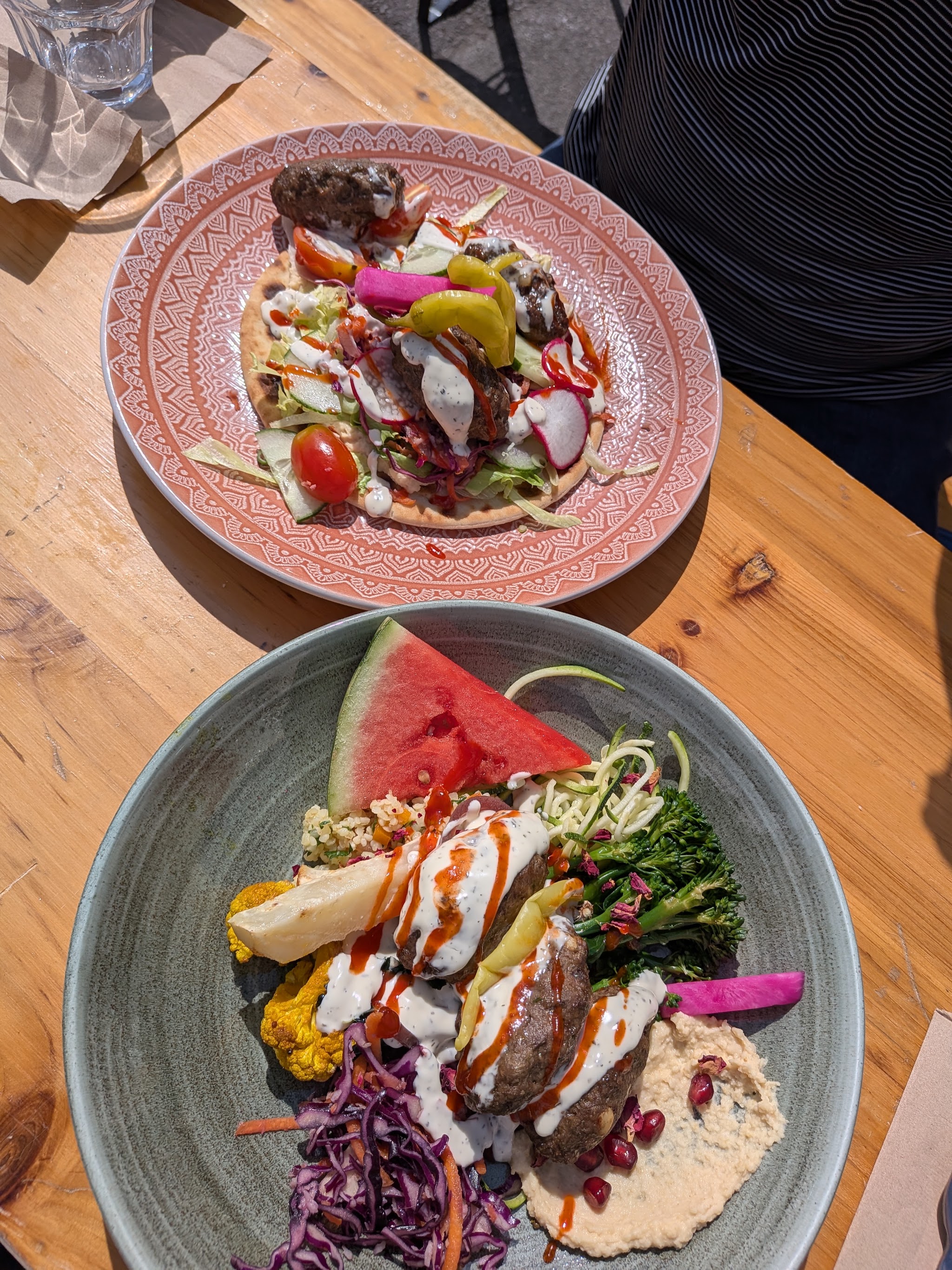Colourful lunch dishes served on an outdoor wooden table